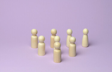 many wooden figures of men stand on a lilac background, the crowd at the rally. Objects at a certain distance