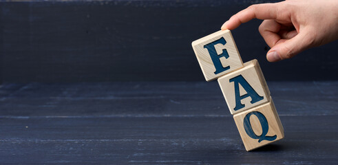 inscription FAQ (frequently asked questions) on wooden blocks on a blue background