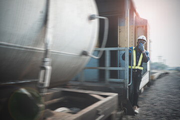 African man engineer holding radio communication or walkie talkie and hanging out of the  train