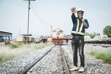 African engineer   control a the train on railway with talking by radio communication or walkie...