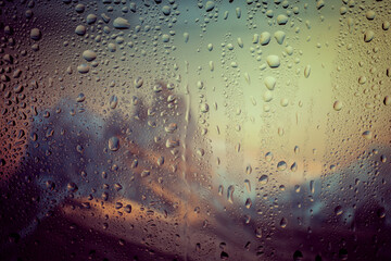 Rain droplets in a window glass, mountains landscape views. Bokeh background.