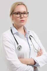 Portrait of a seriously looking female family doctor in doctor's overall with stethoscope