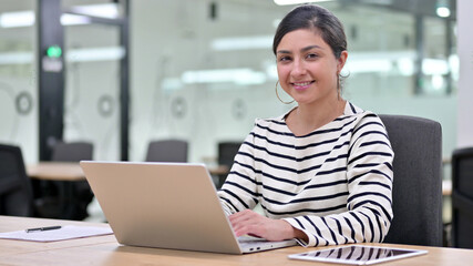 Fototapeta na wymiar Cheerful Indian Woman with Laptop Smiling at Camera 