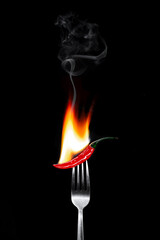 hot red pepper with fire on a fork