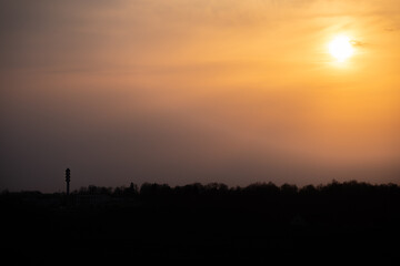 a golden sunset over the city that remains in the dark haze