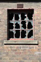 Broken Window in Brick Wall of Derelict Industrial Building 