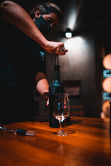 Copa de cristal de degustación de cerca. Sommelier sirviendo vino desde cava. Sacacorchos de botella de vino tinto con manos