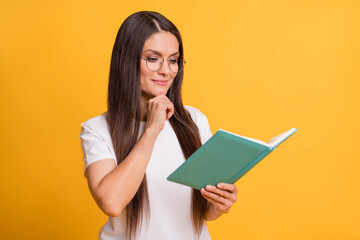 Photo of smart charming minded woman hold hand chin book novel isolated on shine yellow color background