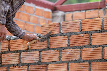 Red bricks and mason are building bricks to build the walls of the building. Working requires...