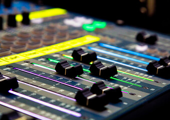 Sliders and buttons on Audio Mixing Desk at live event.