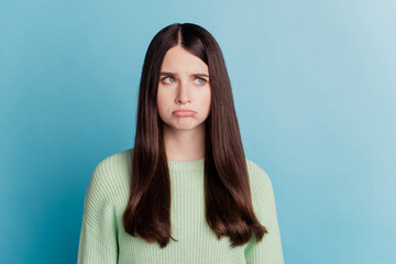Portrait of sad unhappy woman look empty space isolated on turquoise background