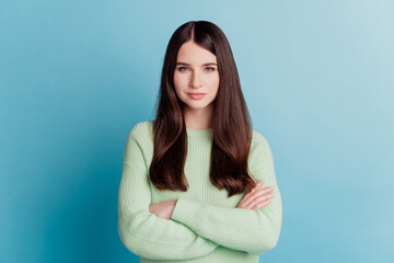 Portrait of confident cool woman crossed hands isolated on turquoise background