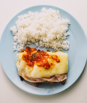 escalopa napolitana de pollo con salsa de tomate, jamon y queso, acompa&ntilde;ada de arroz blanco