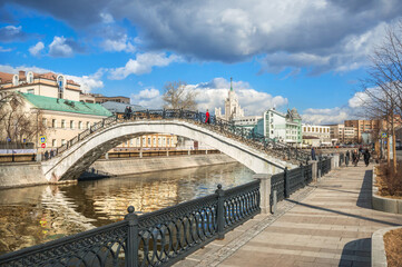 Fototapeta premium Sadovnichesky bridge across the Vodootvodny canal and a skyscraper on Kotelnicheskaya embankment in Moscow
