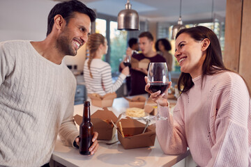 Group Of Multi Cultural Friends Enjoying Drinks Party With Takeaway Food At Home Together