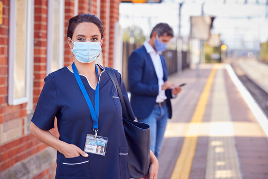 Portrait Of Nurse On Railway Platform Wearing PPE Face Mask Commuting To Work During Pandemic