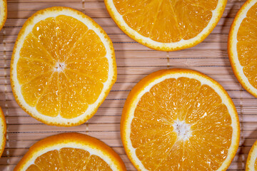 Yellow juicy orange on a bamboo napkin. Background on the theme of fruits, citrus fruits.