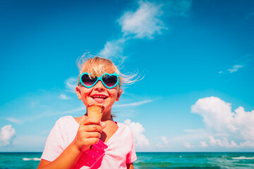 happy cute little girl eating ice cream on beach - 430803787