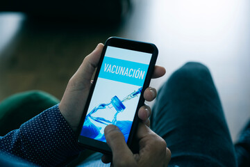 man and text vaccination in spanish in smartphone