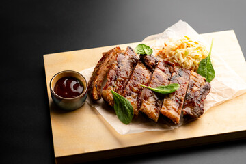 Pork is fried in sauce and sauerkraut, served on a wooden board with sauce.