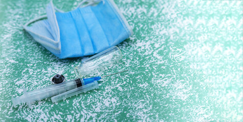 Medical instruments on blue background. Ampoule of medicine and syringe. Medical mask and vaccine.
