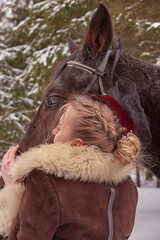 Stylized photo shoot of a girl with a horse in a winter forest.