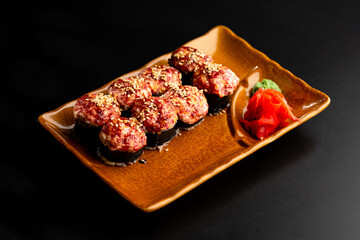 Sushi and rolls, Japanese sea cuisine. Served plates for the restaurant menu on a black background.