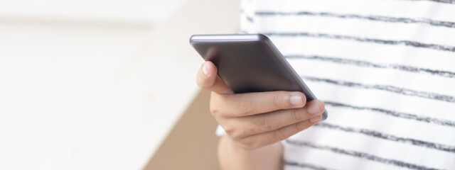 Hand holding and using smartphone.