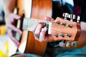 Practicing guitar playing a beautiful Asian man playing guitar