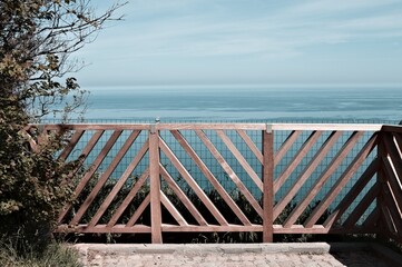 A breathtaking view of the Mediterranean sea from a balcony with a wooden railing (Pesaro, Italy, Europe)