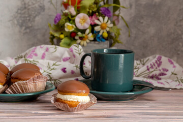 Three cakes on a saucer and a cup of tea close-up