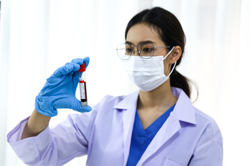 Scientist holding Coronavirus covid-19 infected blood sample tube DNA testing of the blood in the laboratory with blood sample collection tubes and syringe Coronavirus Covid-19 vaccine research.