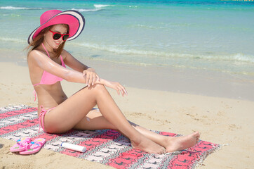 Beautiful Asian girls wearing cute bikini and sunglasses use sunscreen to the beach