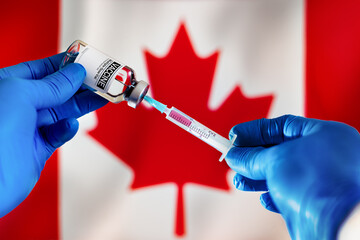 Injecting dose of vaccine in syringe for infections prevention in front of the Canadian flag....
