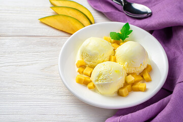Mango ice cream balls and mango slices on a white background with space to copy.