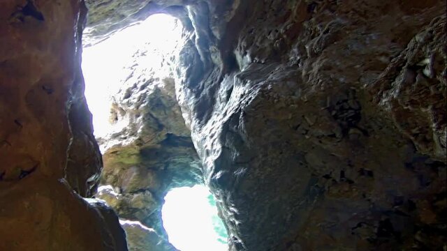 Big holes in the rock of a cliff outcropping the sea. Clifftop.
