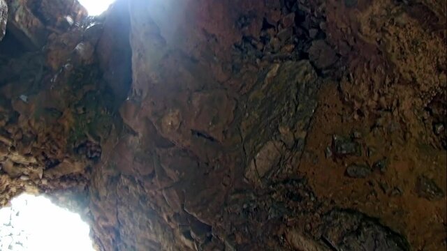 Big holes in the rock of a cliff outcropping the sea. Clifftop.