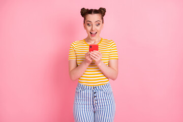 Portrait of astonished funny girl open mouth look phone new comment subscribe isolated on pink color background