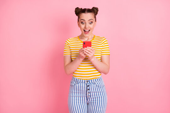 Portrait of astonished funny girl open mouth look phone new comment subscribe isolated on pink color background