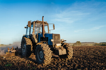 Fototapeta premium The tractor plows the land. Agriculture image