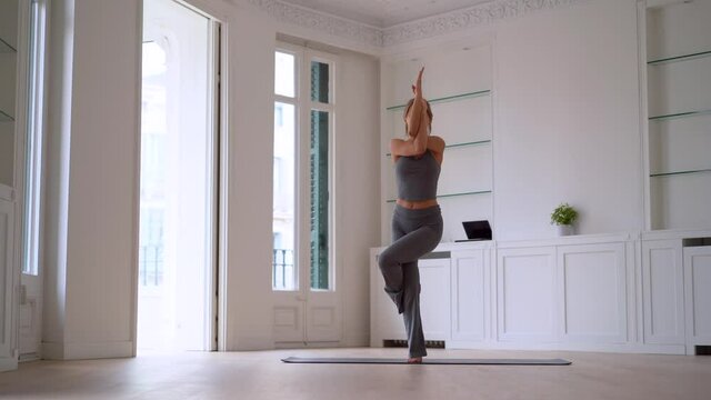 Flexible woman practicing yoga at home