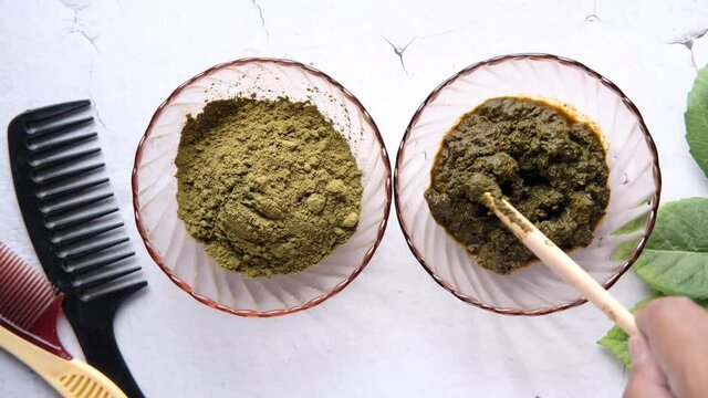 The wooden bowl with rehydrated henna on table 