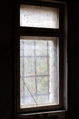 Dirty old window with bars in abandoned house in ghost town Pripyat, Chernobyl Exclusion Zone, Ukraine. Vertical photo