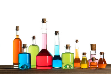 Old style glass bottles on white background. Various magic potions or colorful essential oils in the bottles on the table. Magic spell, potion and poison concept.

