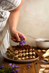 Decorating tiramisu cake with flowers. Cooking coffee cake with sponge finger cookies. Step by step recipe.