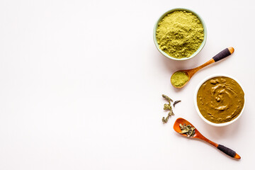 Henna powder in wooden bowl with green leaves. Herbal natural hair dye