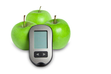 Blood glucose meter with green apples on a white background.