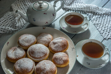 Traditional Czech donuts filled with jam and sprinkled with sugar served with tea