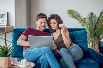 Young couple choosing something for buying online