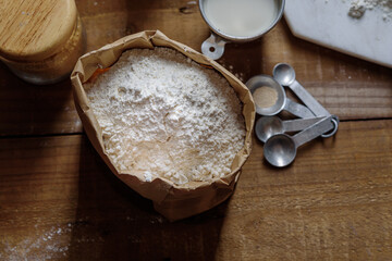 The powder of flour is in a paper bag and placed on a wooden table Prepare for cooking.